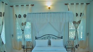 A room with a bed, two chairs, and a window with curtains. - Ngorongoro Corridor Lodge (Karatu)
