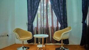 A room with two modern chairs and a small round table. - Ngorongoro Corridor Lodge (Karatu)