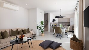 A modern living room with a sofa, coffee table, and dining area.