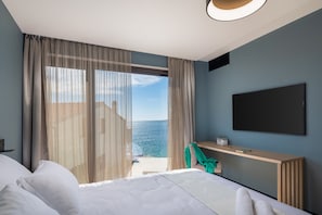 A bedroom with a bed, a desk, and a TV.