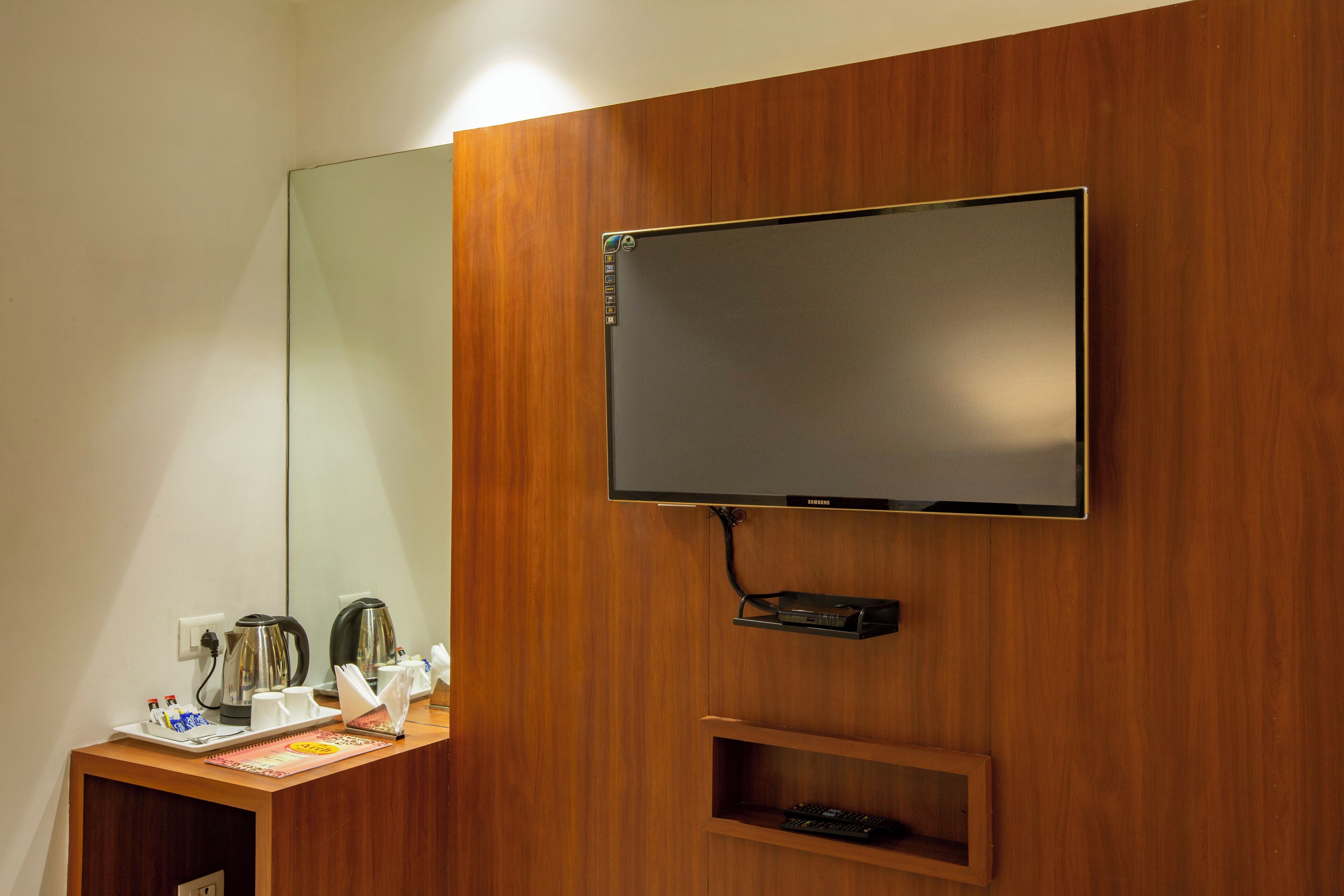 A wooden wall with a flat-screen TV mounted above a wooden shelf.