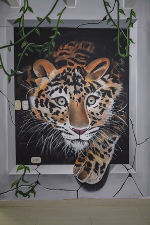 Een schilderij van een luipaardengezicht op een muur.