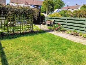 A well-maintained garden with a wooden fence, a bench, and a pathway leading to a house. - 3 bedroom accommodation in Ceres, near Cupar (Ceres, near Cupar)