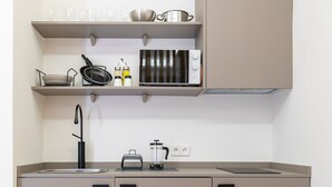 A compact kitchenette with a sink, stove, and storage cabinets. - Nice studio 100 meters from Plaza de Callao (Madrid)