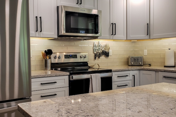 Stainless appliances, quartz countertops and large island with 4 barstools.
