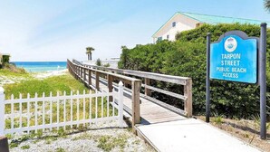 A wooden boardwalk leading to a beach with a sign indicating public beach access at Tarpon Street. - Gorgeous views, sleeps 6, clean, less than 100 steps to beach access.  (Destin)