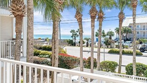 A beachfront property with palm trees, a road, and a parking lot. - Gorgeous views, sleeps 6, clean, less than 100 steps to beach access.  (Destin)