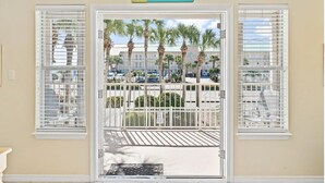 A hotel entrance with a sign reading "RETRIEVE," a white door, and a view of palm trees and parked cars outside. - Gorgeous views, sleeps 6, clean, less than 100 steps to beach access.  (Destin)