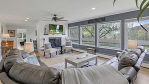 Ein modernes Wohnzimmer mit Kamin, großen Fenstern und Ledersofas.