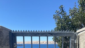 Um portão de metal com vista para a paisagem costeira.