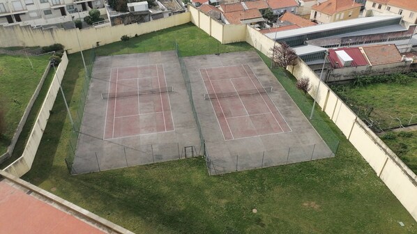 An aerial view of a sports court with surrounding buildings. - Cond Fechado, Piscina, Court de Ténis, Ginásio, Sauna e Banho Turco (Leça da Palmeira)
