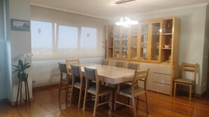 Ein Essbereich mit Holztisch und -stühlen, einem Schrank mit Glastüren und einem Fenster mit Aussicht.