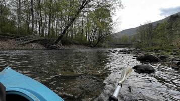A river with a bridge and a kayak.
