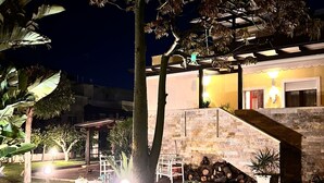 A well-lit outdoor area with a tree, potted plants, and a stone wall. - 1 Bedroom Villa in Noicattaro (Noicattaro)