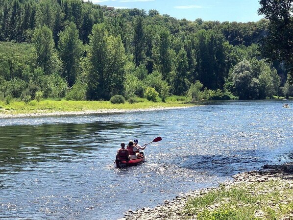 A river with a boat carrying people. - Gîte au Calme en Quercy Entre Sarlat, Lascaux et Rocamadour (Souillac)