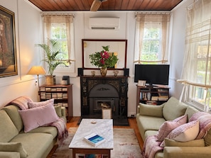 A cozy living room with a fireplace, two sofas, a coffee table, and a television.