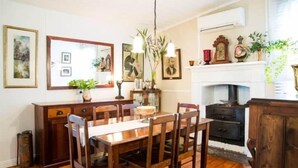 Ein Esszimmer mit Holztisch und -stühlen, einem Spiegel und einem Kamin.