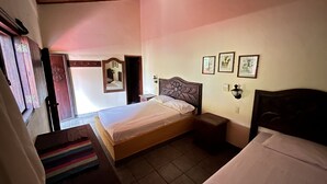 Een slaapkamer met een eenpersoonsbed, een nachtkastje, een kast en een spiegel.