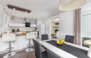 Enjoy a spacious living area with a dining table, kitchen with modern appliances, and a cozy seating area.