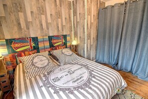 A bedroom with a striped bedspread, wooden headboard, and decorative pillows.