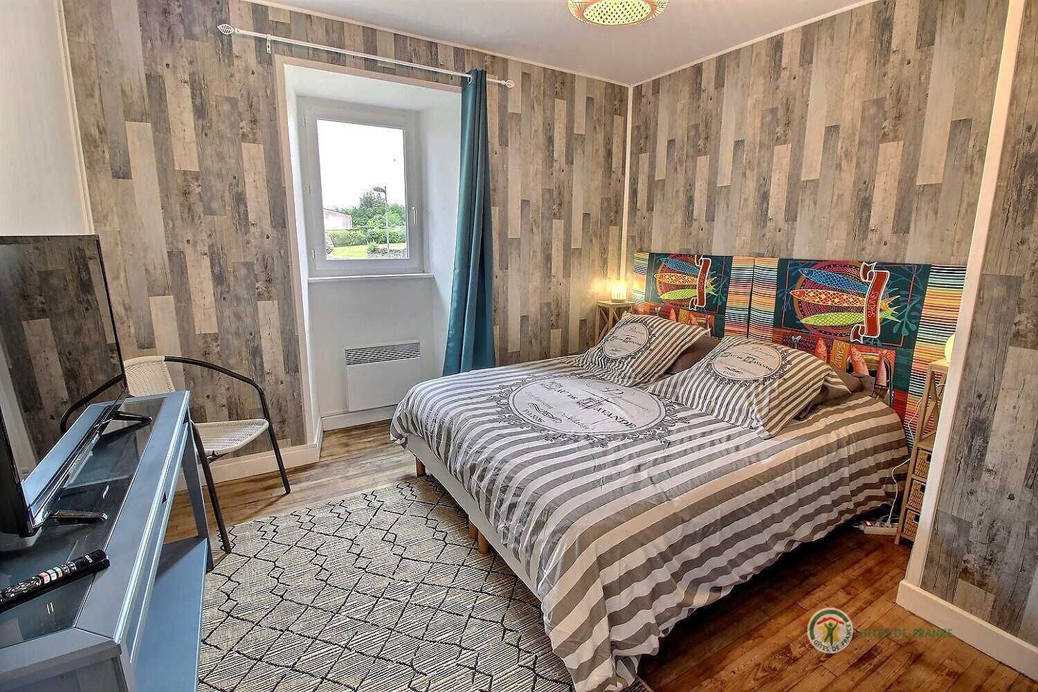 A bedroom with a bed, a desk, and a chair.