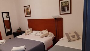A hotel room with two beds, a nightstand with a lamp, and framed pictures on the wall. - Milazzo Luxury Home (Rome)