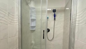 A glass-enclosed shower stall with a white toilet and a water dispenser. - Milazzo Luxury Home (Rome)