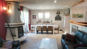 Ein modernes Wohnzimmer mit Kamin, Essbereich und Küche.