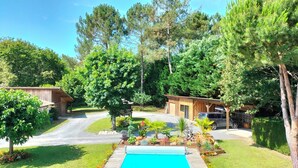 Ein Wohnobjekt mit Pool, Holzhütten und einem gepflegten Garten.