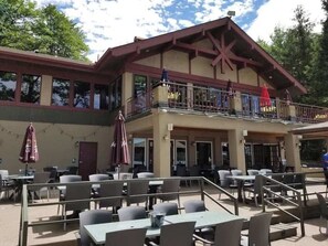 A two-story building with outdoor seating and a balcony.