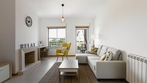 Un salon moderne avec un canapé, un fauteuil, une table basse et une cheminée.