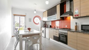 Une cuisine moderne avec un coin repas, un lave-linge et une cuisinière.
