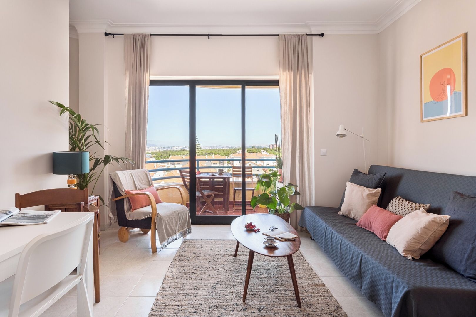 Una sala de estar moderna con un sofá, un comedor y un balcón con vistas.