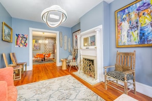 Relax in a cozy space with a plush sofa, wooden chair, and fireplace.