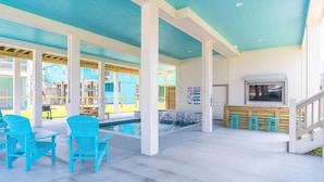 A pool area with blue chairs and a hot tub.