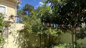 A garden with a lawn, a clothesline, and a building with a tiled roof. - Pavillon 1ER Etage (Setúbal)