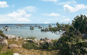 A coastal scene with numerous boats anchored in calm waters, surrounded by rocky terrain and dense vegetation. - 3 bedroom lovely home in Båstad (Båstad)