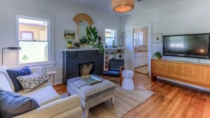 Una sala de estar moderna con chimenea, televisión y comedor.