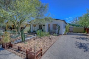 A single-story building with a flat roof, a covered porch, and a paved driveway. - Cute bungalow close to UofA (Tucson)
