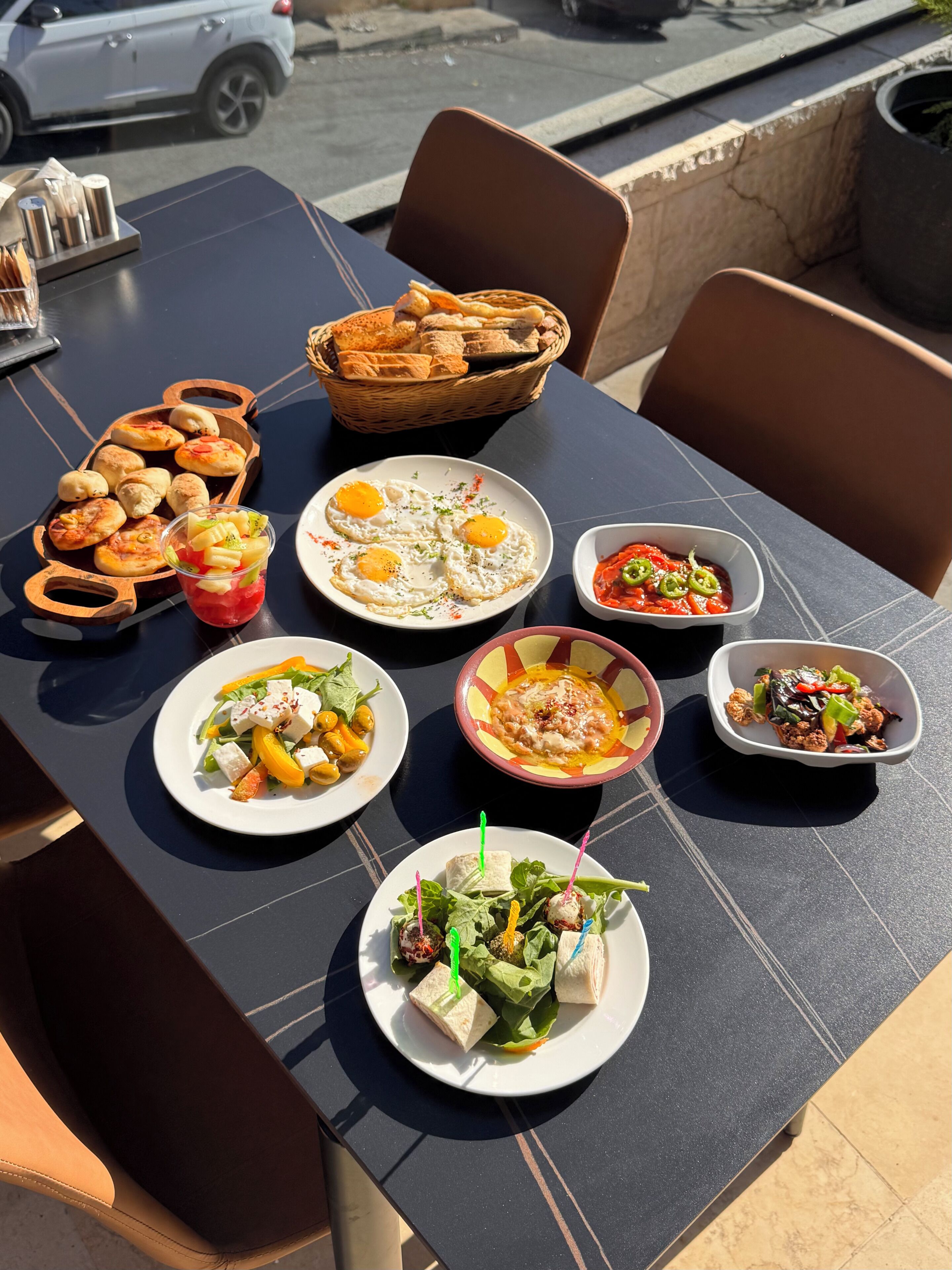 Una mesa con diferentes platos, incluyendo huevos, ensalada y pan.