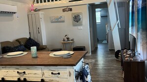 Une cuisine spacieuse dotée d’un îlot central, d’un espace repas en mezzanine et offrant une vue sur le salon.