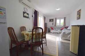 Un comedor con una mesa, sillas, un sofá, una cama y un televisor.