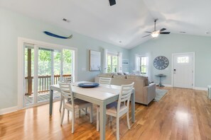 Amplia sala de estar con mesa de comedor, sofá y ventilador de techo.