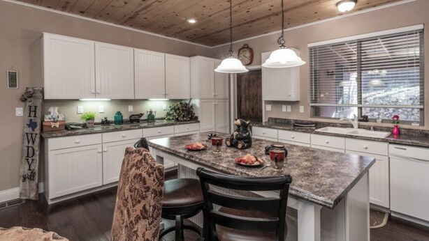A kitchen with a large island, white cabinets, and pendant lighting. - Sandy Bear - Stunning cabin in the Heart of Ruidoso w priv tub (Ruidoso)