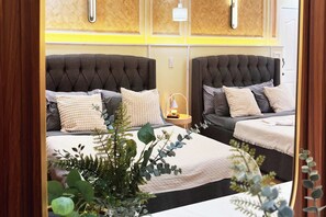 A hotel room with two beds, each with a tufted headboard, a bedside table with a lamp, and a large window with a view. - Torres Farm Resort powered by Cocotel (Naic)