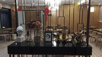 Ein modernes Interieur mit einer Rezeption, einem Essbereich und einer Chandelier.