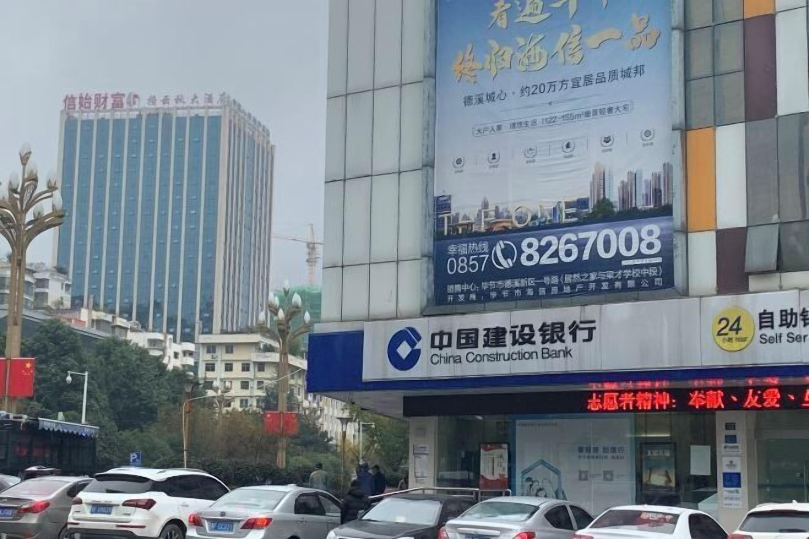 A commercial building with a large advertisement and a bank sign.
