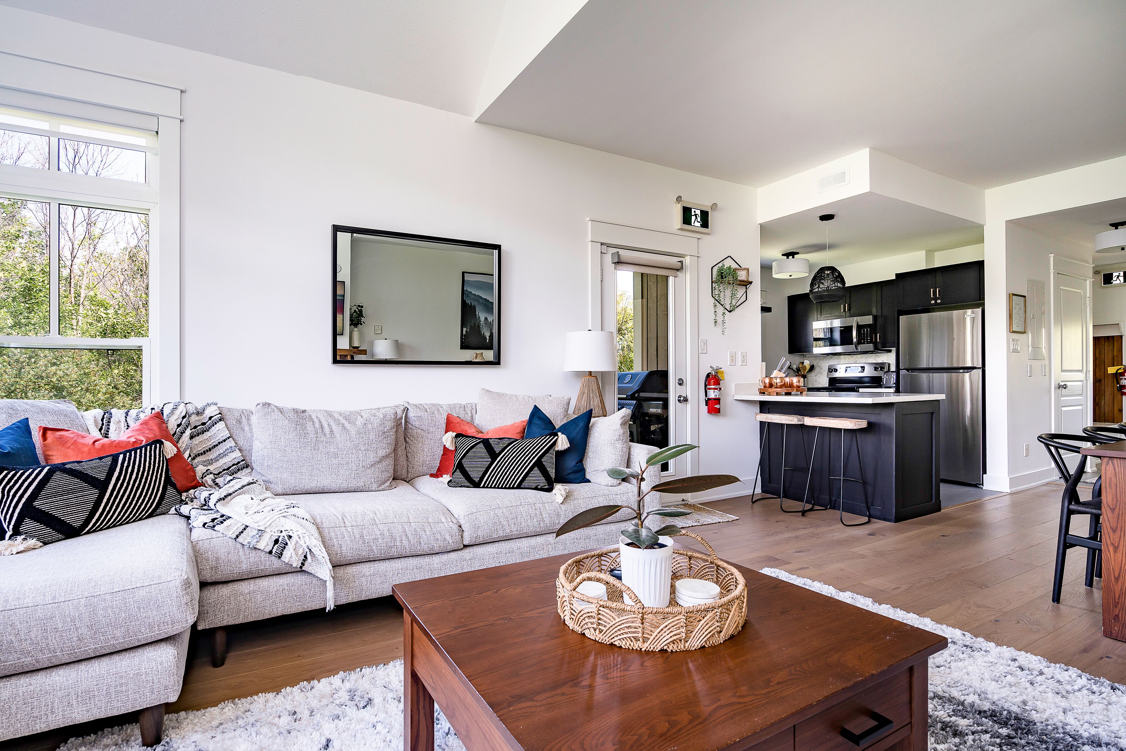 Een moderne woonkamer met een bank, salontafel en uitzicht op de keuken.