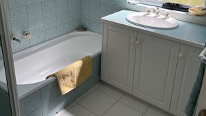A bathroom with a bathtub, a sink, and a window. - Enjoy a Break Away in This Lovely Home With Great Views (Middleton)