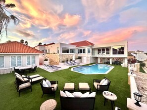 A modern house with a swimming pool, outdoor seating, and a well-maintained lawn. - Aruba Beach Retreat by Bocobay (Noord)
